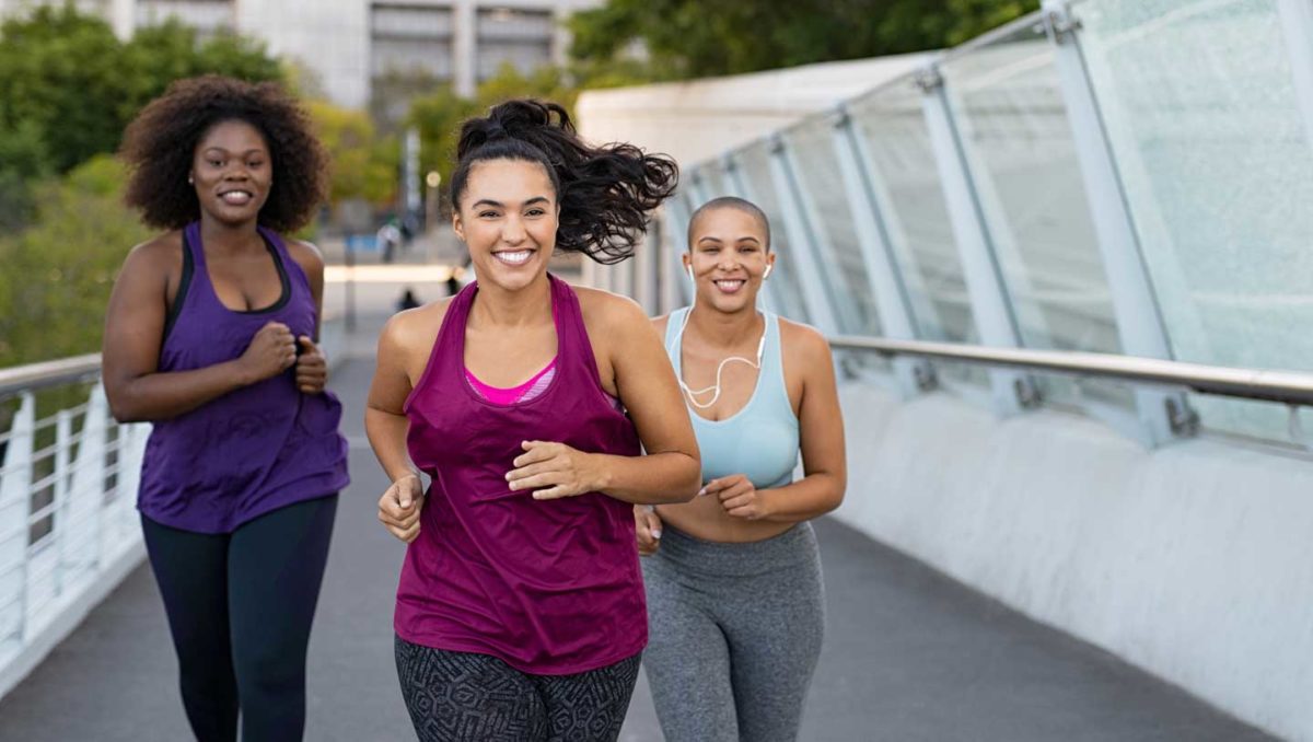 Photo of three women smiling on an outdoor jog